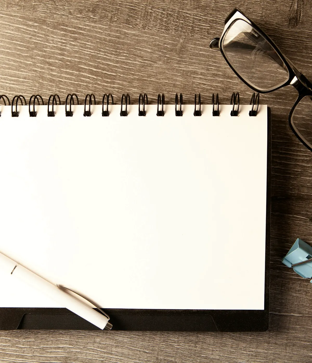 Carnet, lunettes et stylo posés sur le bureau